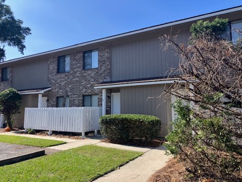 A building with a grey facade and a white fence.