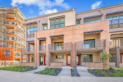 a brick building with two balconies and a sidewalk