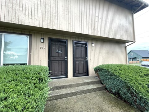 The image shows a building with two black doors, one of which is numbered 409.
