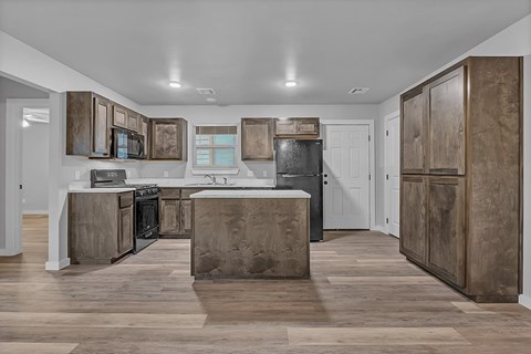 A kitchen with wooden cabinets and a black stove top oven.