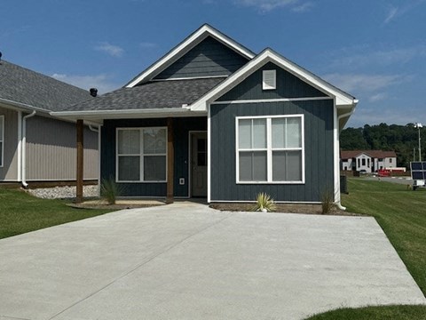 a blue house with a white sidewalk in front of it