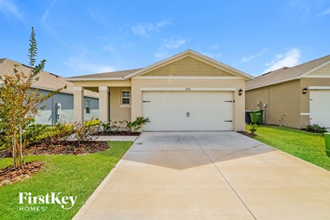 a beige house with a driveway and a garage door