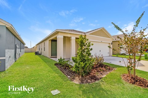 a house with a lawn and a yard with grass and trees