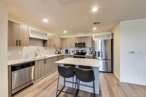 a modern kitchen with stainless steel appliances and a white counter top