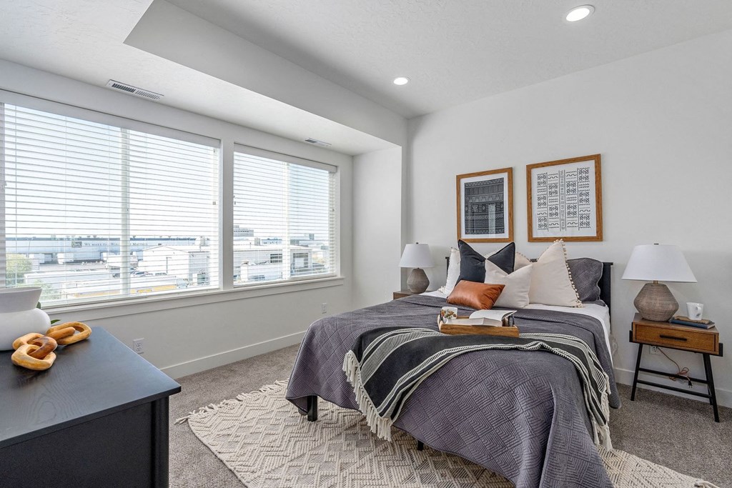 a bedroom with a bed and two windows