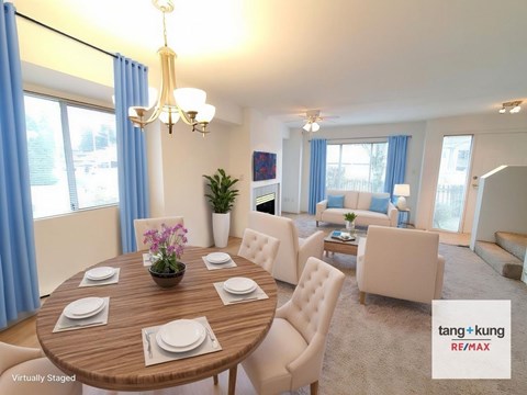 A dining room with a round table set for six with white plates and a vase of flowers in the middle.