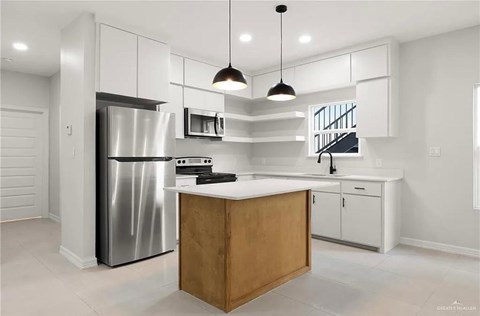 a kitchen with white cabinets and a stainless steel refrigerator
