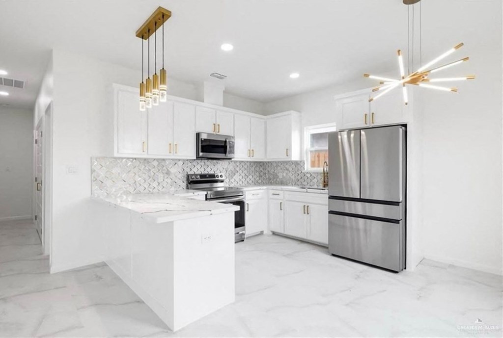 a white kitchen with stainless steel appliances and white cabinets