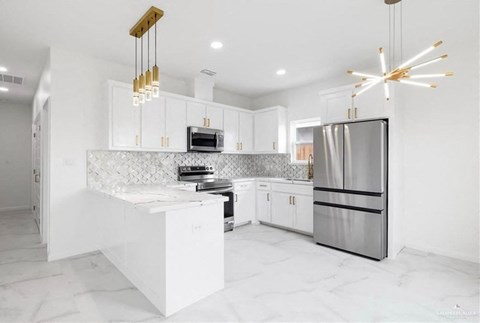 a white kitchen with stainless steel appliances and white cabinets