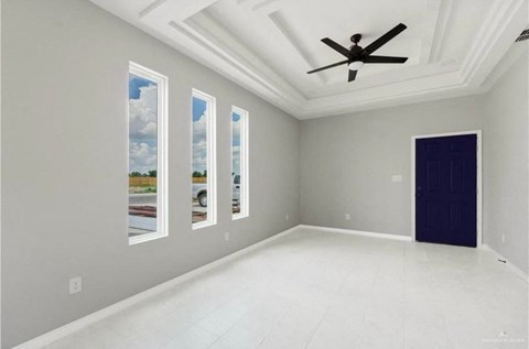 an empty living room with a ceiling fan
