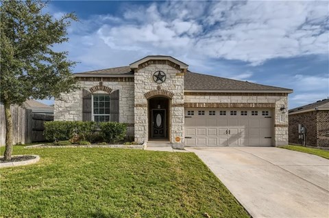 A house with a stone facade and a large front yard.