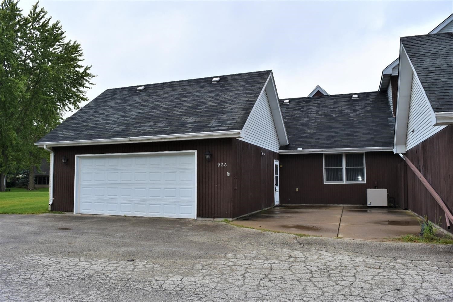 a garage with a white door in front of a house