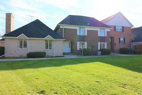 a large brick house with a lawn in front of it