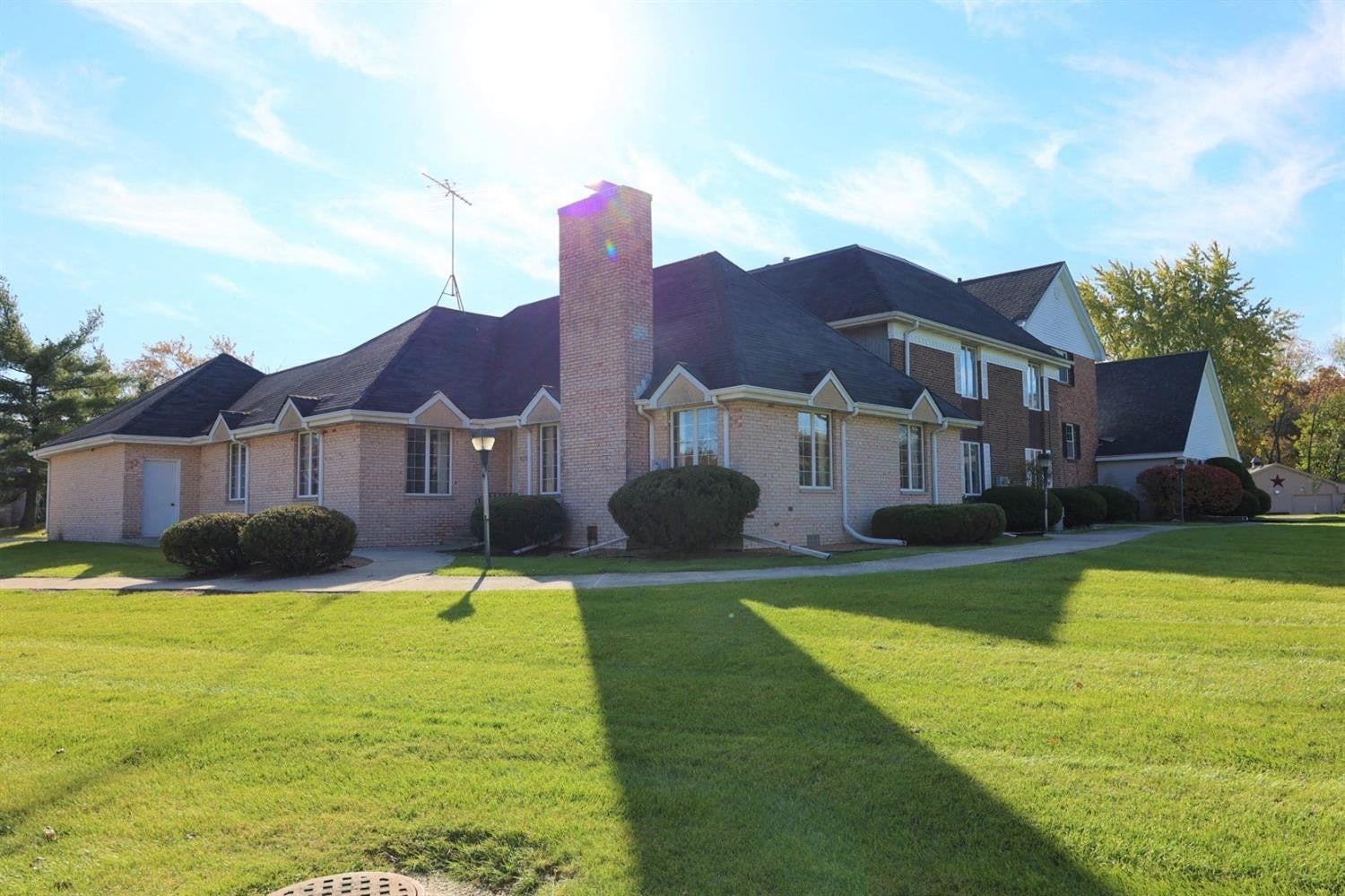 a large brick house with a lawn in front of it