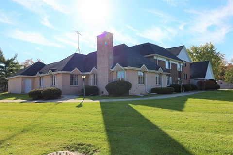 a large brick house with a lawn in front of it