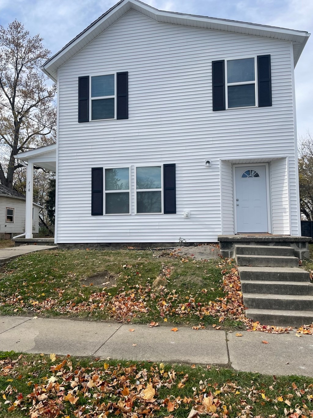 A white house with black shutters and a white door.