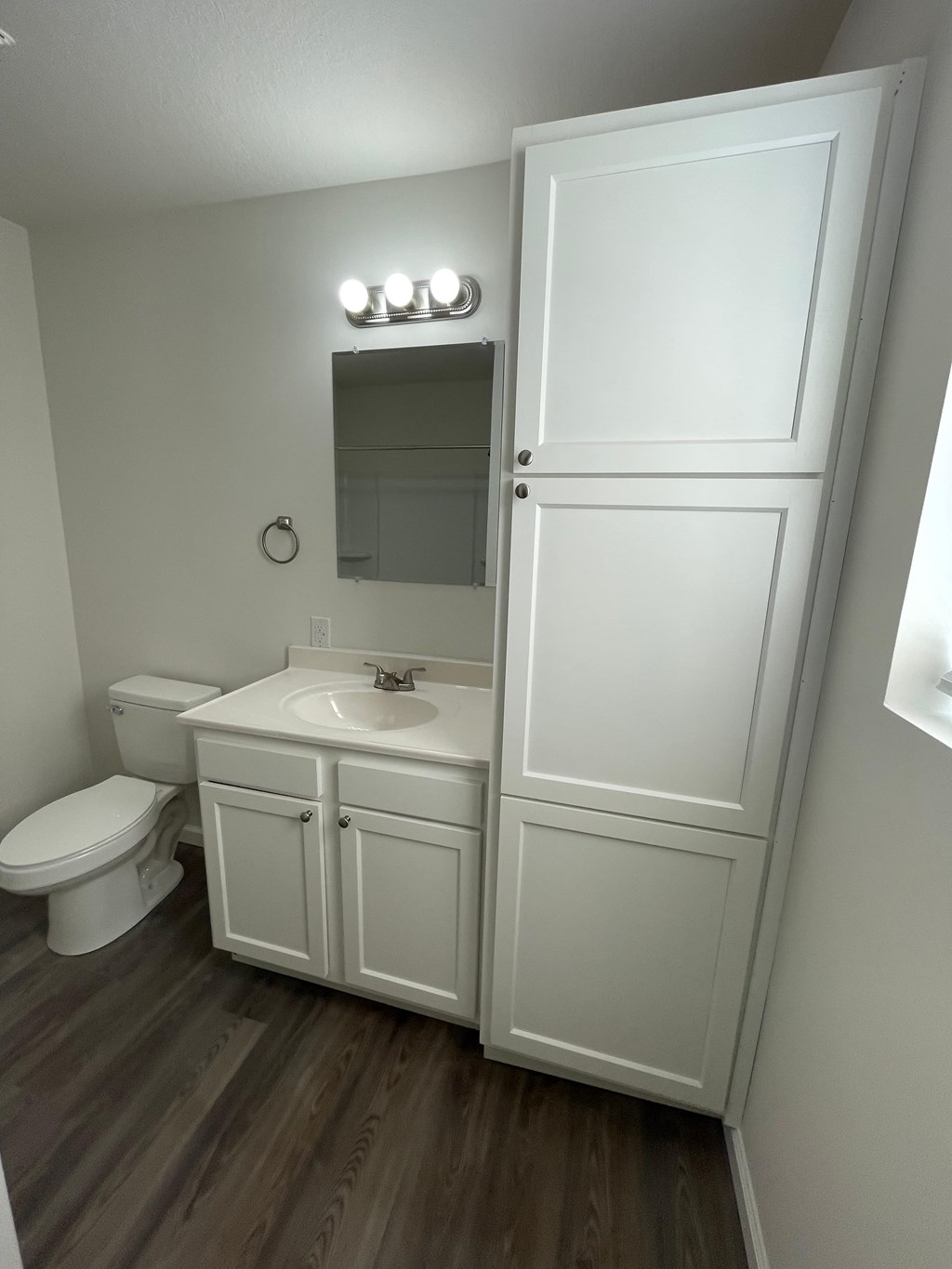 A white bathroom with a toilet, sink, and medicine cabinet.