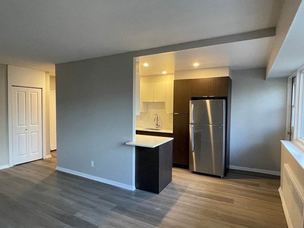 A kitchen with a refrigerator and a counter.