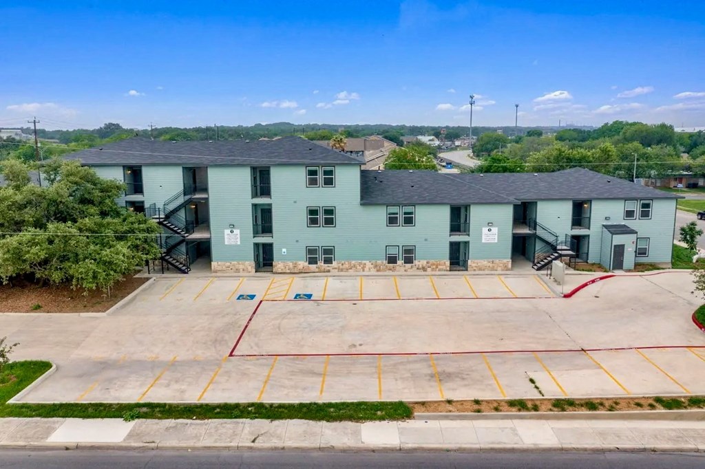 an aerial view of a building with an empty parking lot