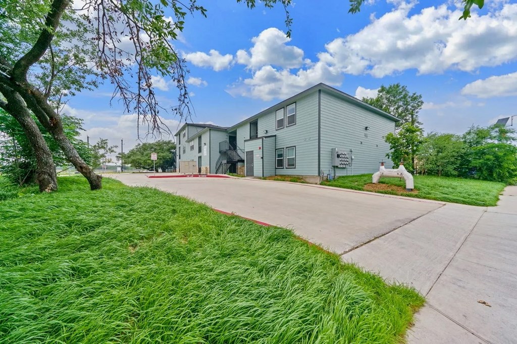 a white house with green grass and a sidewalk