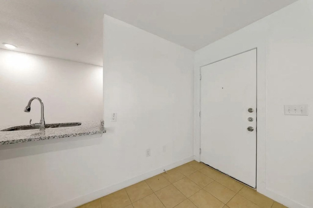 an empty room with a sink and a door