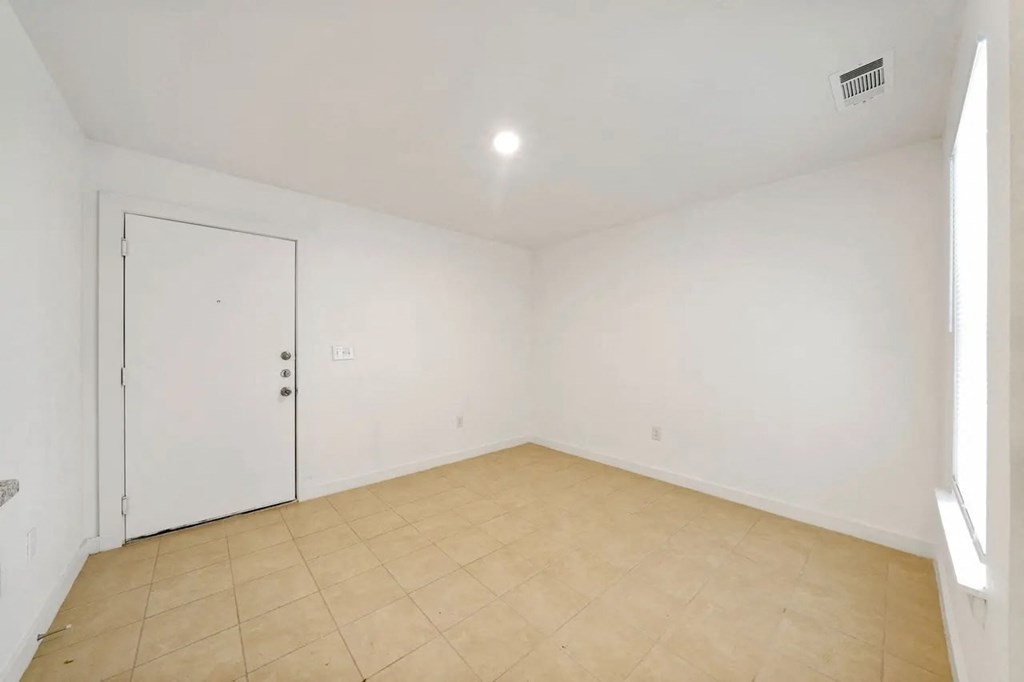 an empty living room with white walls and a white door