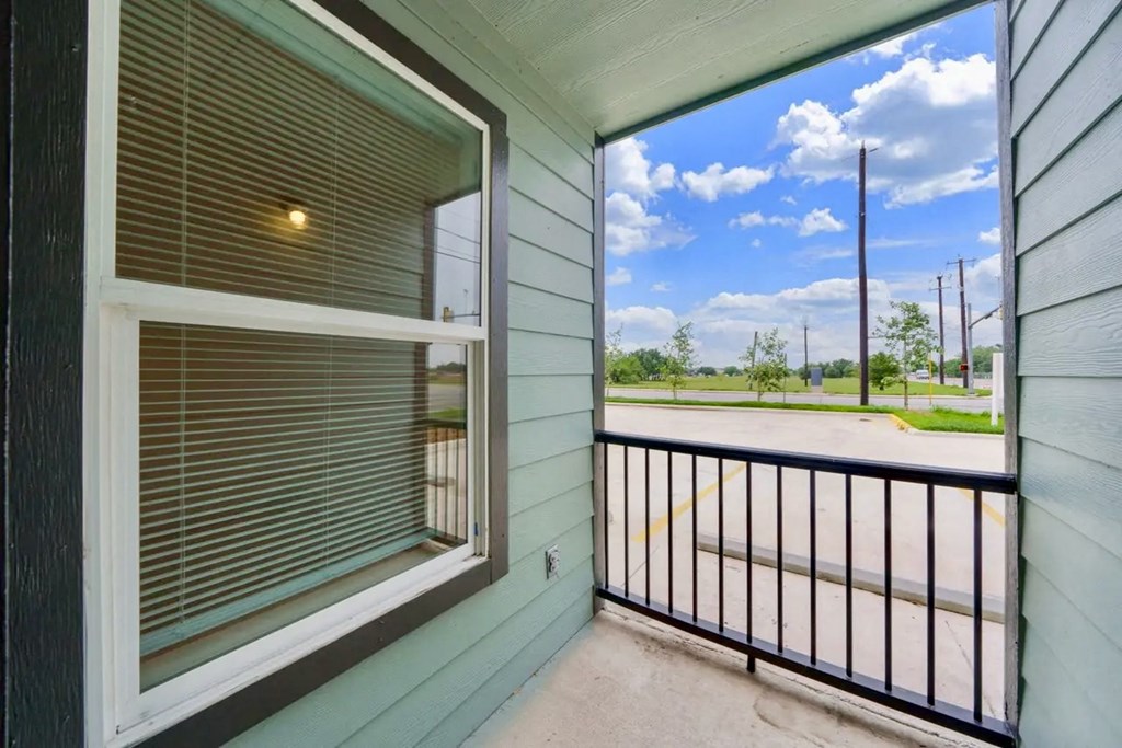 the view from the balcony of a small green house with a window and a railing