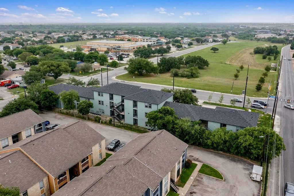 an aerial view of a neighborhood of houses with cars parked on the street