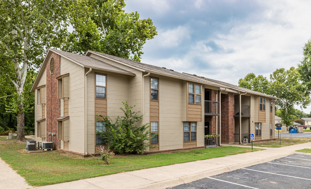 Apartment building with a parking lot in front.