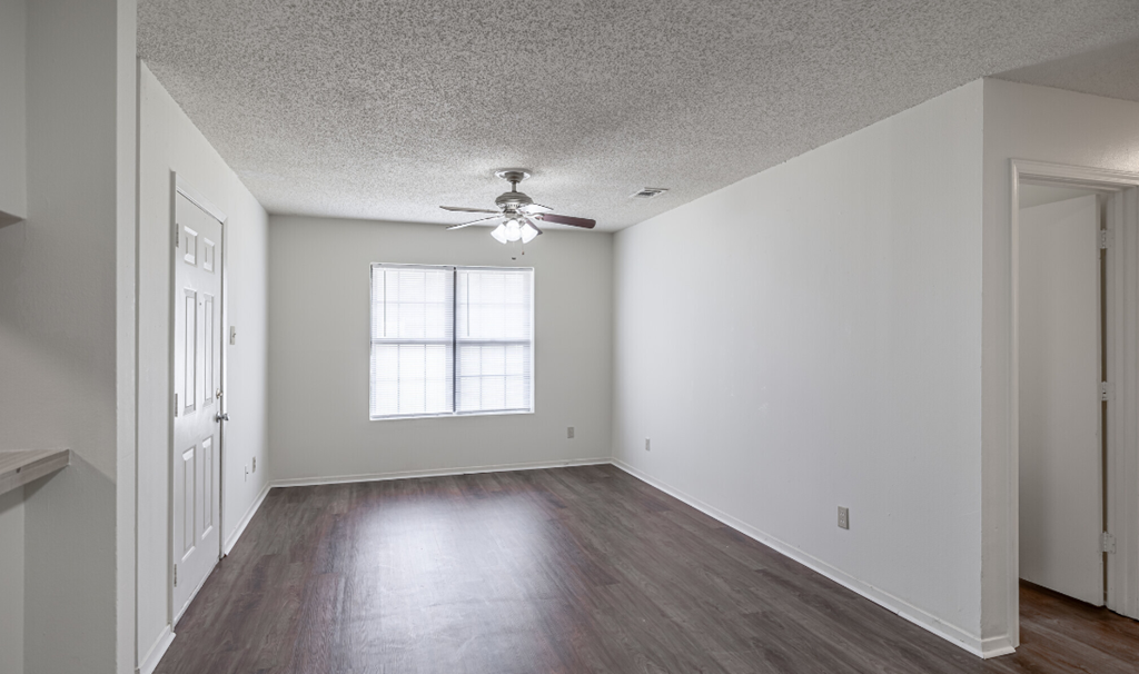 A room with a ceiling fan and a window.