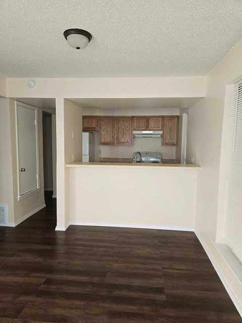 A kitchen with wooden floors and white walls.