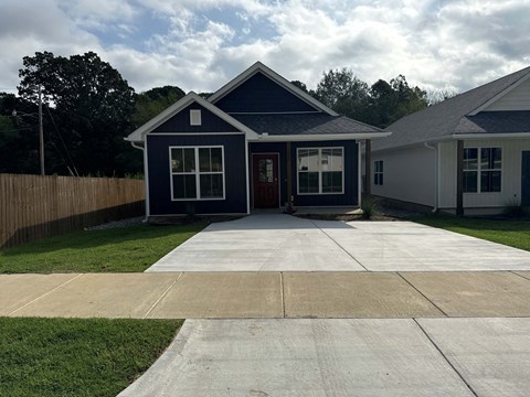 a blue house with a driveway and a lawn