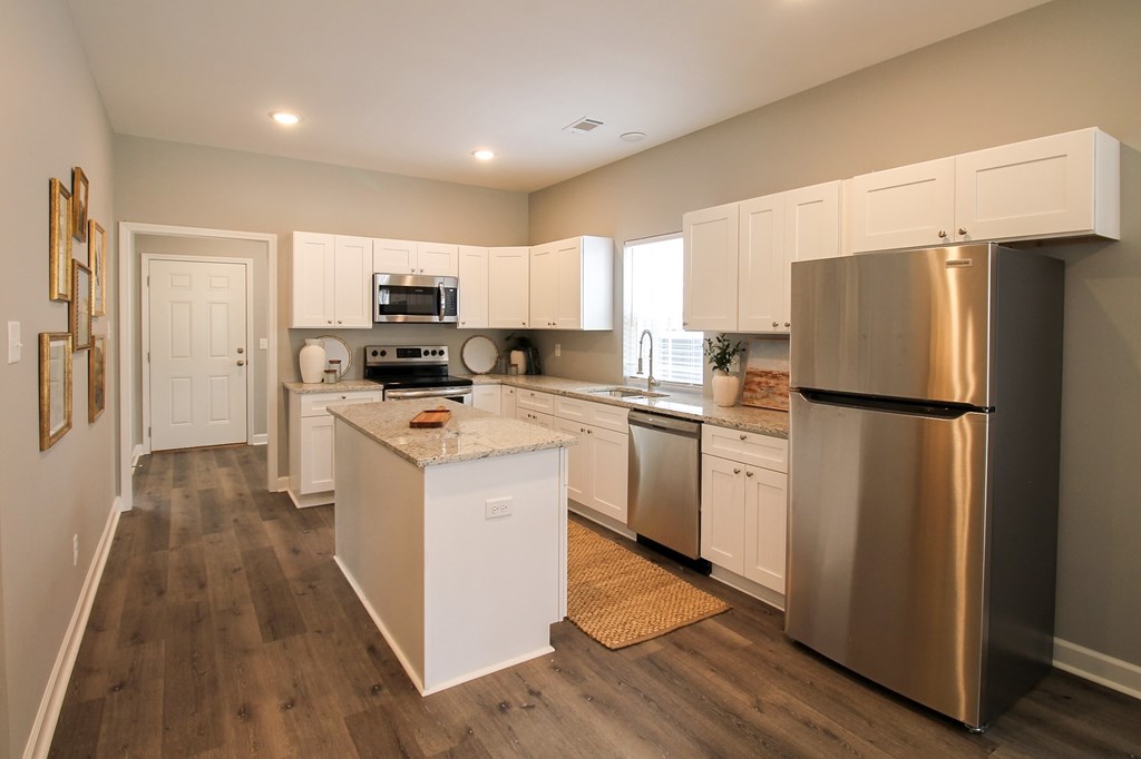 a large kitchen with stainless steel appliances and white cabinets