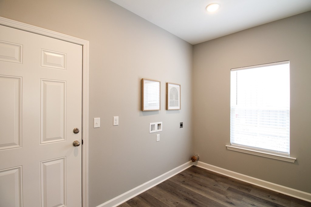 an empty room with a white door and a window
