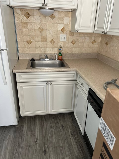 a small kitchen with white cabinets and a sink