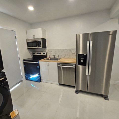 A modern kitchen with stainless steel appliances and white cabinets.