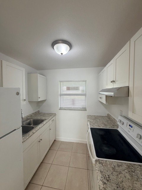A kitchen with white cabinets and a black stove top.