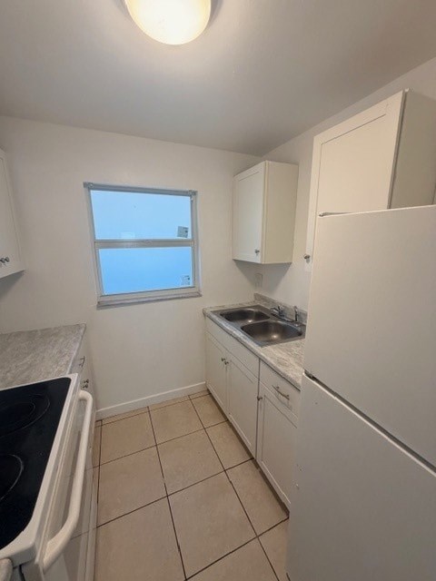 A small kitchen with white appliances and cabinets.