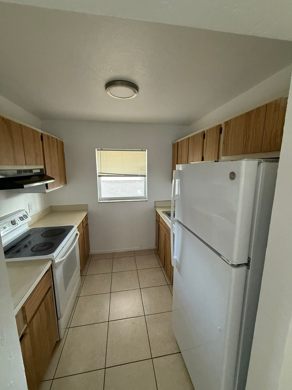 A kitchen with a white refrigerator, white oven, and white stove.
