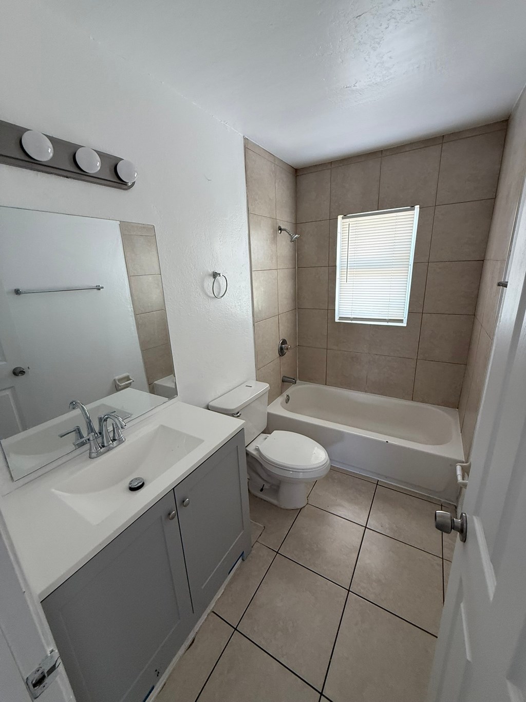 A white sink with a silver faucet is in a bathroom with a white toilet and a bathtub.
