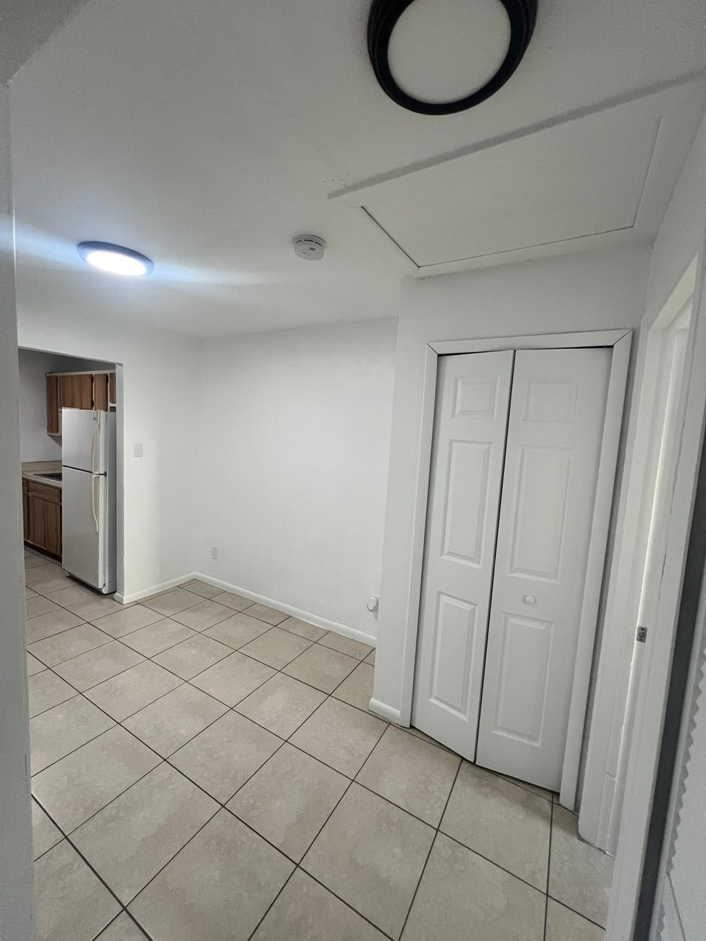 A white door is in a room with tile flooring.