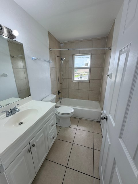 A white bathroom with a sink, toilet, and bathtub.