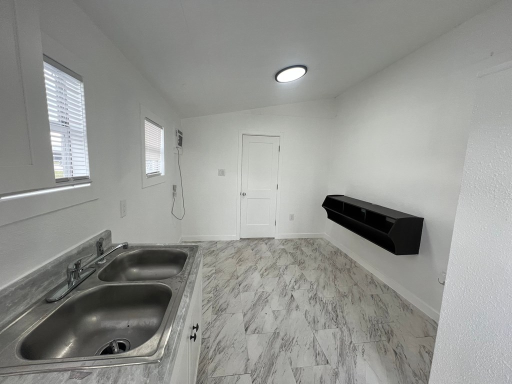 A kitchen with two sinks and a marble floor.