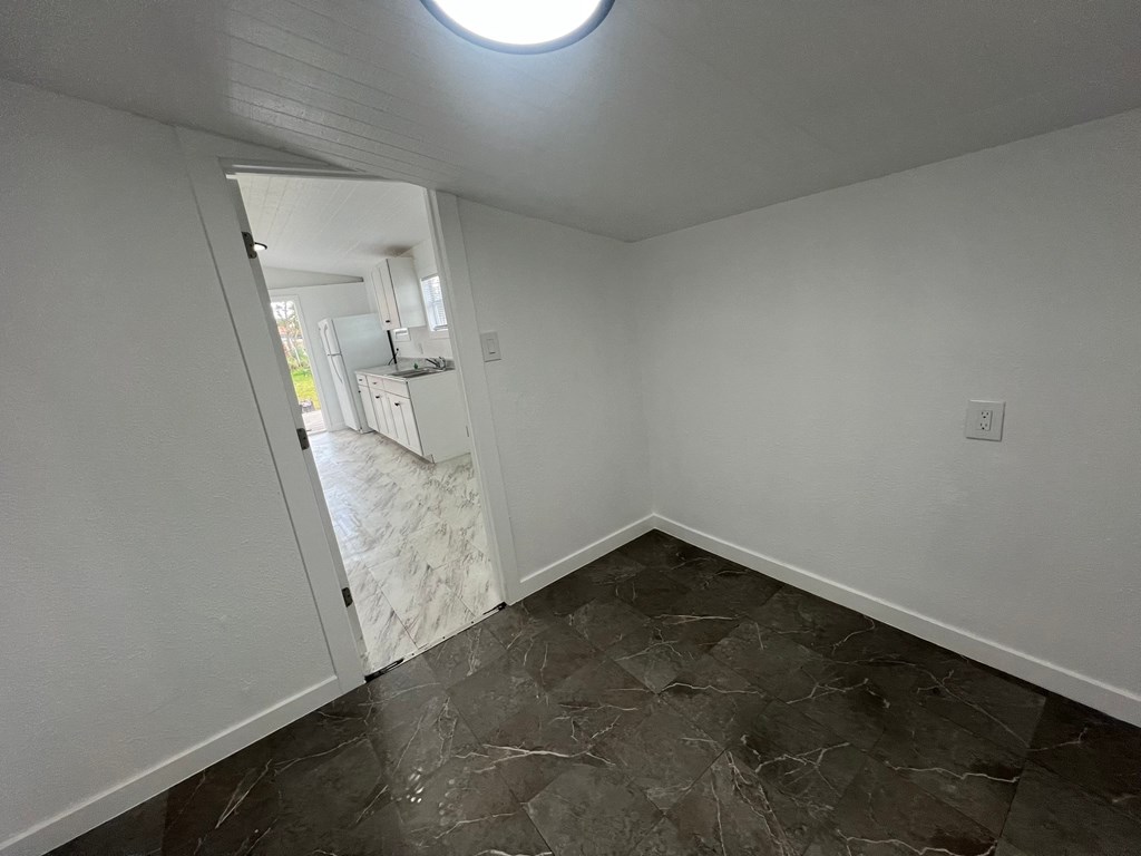 A room with a marble floor and a round window.