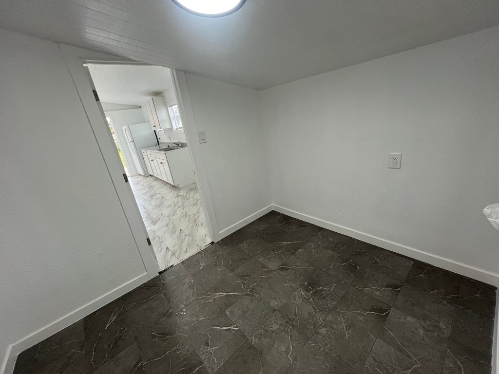 A room with a marble floor and white walls.