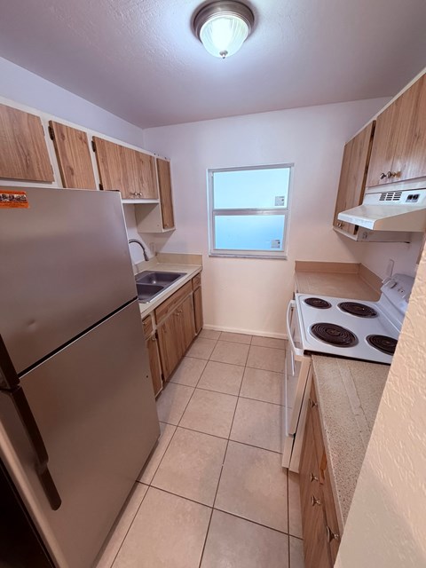A kitchen with a stove top oven and a refrigerator.