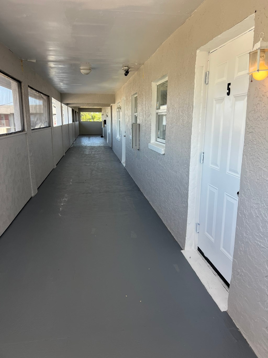 A long white hallway with doors on both sides.