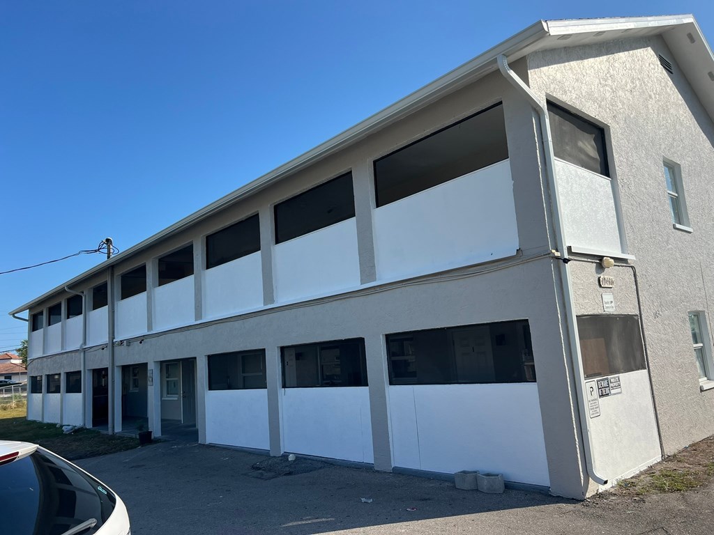 A two-story building with a white exterior and multiple windows.