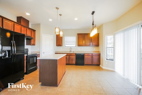 a large kitchen with black appliances and wooden cabinets
