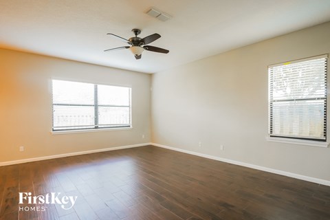 a living room with wood floors and a ceiling fan